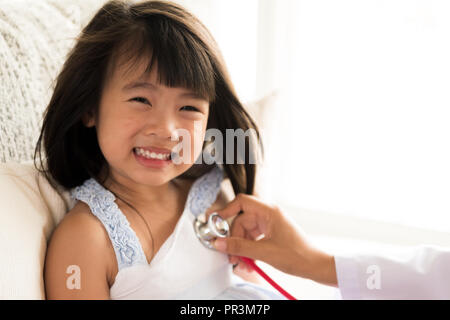 Medico di esaminare una bambina utilizzando uno stetoscopio. Medicina e cure sanitarie concetto. Foto Stock