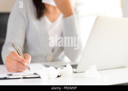 Young business woman malati in ufficio, mano azienda s tessuto e neezing in un tessuto bianco. portatile sul tavolo. Sanità e medicina concetto. Foto Stock