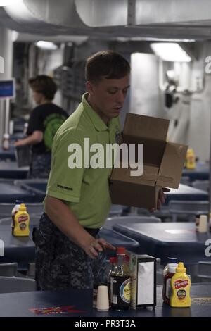 Oceano atlantico (Luglio 22, 2017) pasticcio Deck Master-at-Arms Electronics Technician (nucleare) terza classe Seth Stahl luoghi nuovi condimenti su un tavolo in cucina a poppa in preparazione per la prima colazione a bordo della portaerei USS Harry Truman (CVN 75). Truman salpa verso il basso il fiume di Elizabeth, uscire Norfolk Naval Shipyard (NNSY) a seguito di un periodo di dieci mesi prevista disponibilità incrementale (PIA), per iniziare le prove in mare. Foto Stock