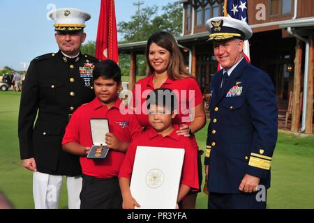 Stati Uniti Marine Corps Lt. Col. Jeff Buffa, 4° Battaglione di ricognizione e Adm posteriore. Dave Callahan, 8 Coast Guard District commander, prendetevi un momento per una foto con la famiglia di pensionati Marine Corps Master Sgt. Rodney Buentello dopo una cerimonia di postumo award gold Medal salvavita di luglio 31, 2017 a San Antonio. La Gold Medal salvavita, uno degli Stati Uniti medaglie più antico, è stato creato da un atto del Congresso nel 1874 e possono essere assegnati a un individuo che si esegue un salvataggio o i tentativi di salvataggio di qualsiasi altra persona da annegamento, naufragio o altri pericoli di acqua, al rischio di sua o Foto Stock