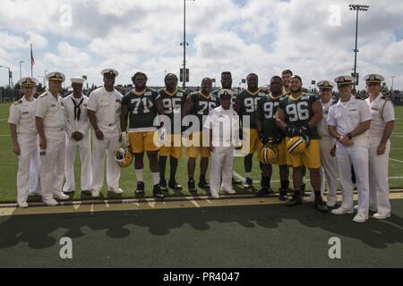 GREEN Bay, Wisconsin (28 luglio 2017) - membri di Green Bay Packers della National Football League, entra a far parte di un gruppo di marinai per una foto sul margine del Packers' campo pratica, durante il Green Bay/Fox Cities Navy settimana. Navy settimana programmi servono come NEGLI STATI UNITI Navy Il principale sforzo di divulgazione in aree del paese che la mancanza di una significativa presenza della Marina Militare, aiutando gli americani a capire che il loro Marina è distribuito in tutto il mondo, circa l'orologio, pronto a difendere l'America in tutti i tempi. Foto Stock