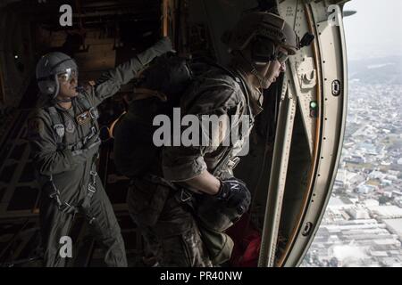 Il personale Sgt. Justin Bender, 374 Operations Support Squadron sopravvivenza, evasione, la resistenza e la fuga specialista, si prepara ad effettuare una linea statica di saltare fuori di un C-130J Super Hercules su Yokota Air Base, Giappone, 28 luglio 2017, durante una missione di addestramento. La formazione non solo ha permesso la sere a praticare il salto, ma ha anche permesso la Yokota personale di volo per mettere in pratica il personale scende e mantenendo le loro qualifiche. Foto Stock