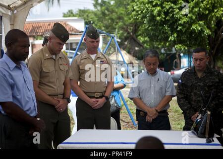 Stati Uniti Marine Capt. Jarrod D. Deitrich, sinistra, Honduras sito ufficiale in carica con la logistica di elemento di combattimento per scopi speciali Air-Ground Marine Task Force - Comando del Sud e Stati Uniti Marine Il Mag. Teodoro R. Smith, responsabile del LCE, SPMAGTF-SC, prua le loro teste durante l invocazione a una cerimonia del taglio del nastro per il Taufick Bendeck Scuola Elementare di Trujillo, Honduras, 27 luglio 2017. I marines stanno conducendo progetti per migliorare le infrastrutture a livello locale nelle scuole di Trujillo su richiesta del governo di Honduras. I marines e i marinai di SPMAGTF-SC sono distribuiti al cen Foto Stock