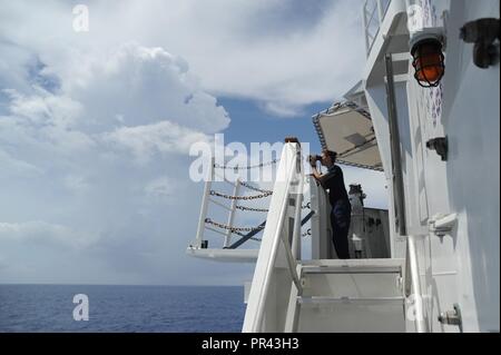 Coast Guard Petty Officer di terza classe di pagina di Elizabeth mans il belvedere sulla Guardacoste Tampa, mentre in corso nel Mar dei Caraibi, 24 luglio 2017. La Tampa, un 270-piede di medie endurance taglierina, è in grado di fornire una vasta gamma di missioni, per includere la ricerca e il salvataggio e il contatore di pattuglie di farmaco. Coast Guard Foto Stock