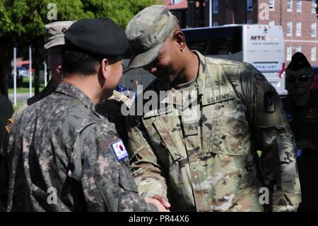 Brig. Gen. Se Woo Pyo, il sud coreano rappresentante, sinistra, presenta una moneta a Sgt. Isaia Terra, dalla 62ª Brigata medica, durante la DIA militari stranieri orientamento Attaché di viaggio sul set. 6, 2018 a base comune Lewis-Mccorda, Washington. La moneta è stata presentata per dimostrare la partnership internazionale tra la Corea del Sud e gli Stati Uniti. Foto Stock