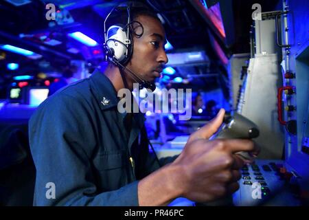 Di Gibilterra (sett. 8, 2018) - Fire Controlman 3rd Class Thomas Williams sta guardare al traguardo ottico console di sistema a bordo della Arleigh Burk-class guidato-missile destroyer USS Ross (DDG 71) nello Stretto di Gibilterra, Sett. 8, 2018. Ross, distribuita a Rota, Spagna, è il suo settimo patrol NEGLI STATI UNITI Sesta flotta area di operazioni a sostegno degli Stati Uniti per gli interessi di sicurezza nazionali in Europa e in Africa. Foto Stock