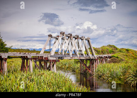 Il legno in disuso Railway Bridge crossing Mahinapua Creek vicino a Hokitika sul'Isola Sud della Nuova Zelanda West Coast. Foto Stock