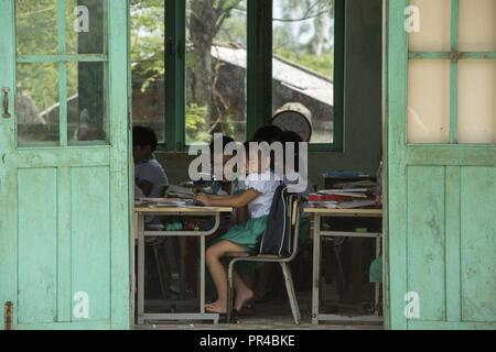 Gli studenti di Phan Dinh Phung Scuola Primaria prendere un peek in USA e servizio australiano ai membri che lavorano sulla loro scuola durante l angelo del Pacifico (PAC ANGEL) 18-2 in Tam Phuoc comune, l'unità PHU Ninh district, Vietnam, Sett. 11, 2018. Durante il PAC ANGELO 18-2 ingegneri civili ha lavorato sulle riparazioni, ristrutturazioni e gli aggiornamenti alle attuali otto medico rurale e delle strutture scolastiche. PAC Angel è un multilaterale di assistenza umanitaria civile e militare, di impegno che migliora di strutture militari di partenariati nell'Indo-Pacifico fornendo anche la salute medica outreach, civico progetti ingegneristici e oggetto Foto Stock