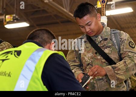 Spc. Tien T. Trinh, 320Polizia Militare battaglione, Ashley, Penn., mani sulla sua M9 pistola ad una mobilitazione e distribuzione (MAD) brigata contraente dopo che l'unità dell'arrivo Biggs Army Airfield in Fort Bliss sett. 9. La 320MP Battaglione, insieme con il 310th MP Battaglione fuori Farmingdale, N.Y., sono tornati a casa dopo aver completato il loro tour yearlong del dazio a Guantánamo Bay a Cuba. Foto Stock