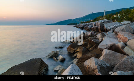 Tramonto sulla spiaggia sotto il faro di Trieste, Friuli Venezia Giulia, Italia Foto Stock