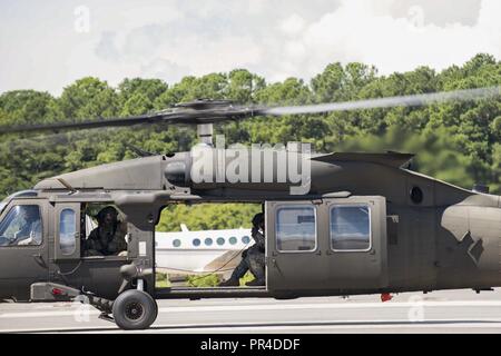 Stati Uniti I soldati dell esercito assegnati al 5° Battaglione (supporto generale), 159Reggimento aviazione spostare un UH-60 Black Hawk in preparazione per l'uragano Florence a base comune Langley-Eustis, Virginia, Sett. 11, 2018. Gli aerei sono stati spostati in hangar a causa dell'Uragano Firenze la minaccia di forti venti e inondazioni costiere. Foto Stock