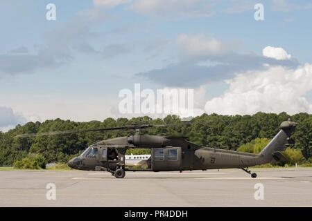 Stati Uniti I soldati dell esercito assegnati al 5° Battaglione (supporto generale), 159Reggimento aviazione spostare un UH-60 Black Hawk elicottero in preparazione per l'uragano Florence a base comune Langley-Eustis, Virginia, Sett. 11, 2018. Come con il helicopers e navi su Fort Eustis, F-22 rapaci e T-38C artigli sono state evacuate per il Rickenbaker Air National Guard Base in Ohio. Foto Stock