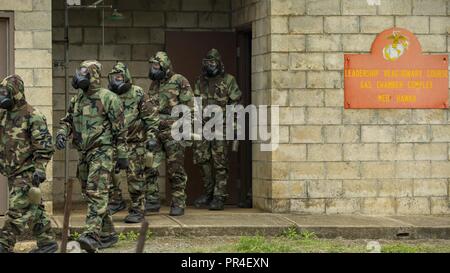 Stati Uniti Marines con il 3° Reggimento Marine per uscire da una camera del gas che indossa la missione orientata postura protettiva (MOPP) ingranaggio dopo la conduzione di gas annuale di formazione della camera durante la settimana del guerriero su Marine Corps base Hawaii, Kaneohe Bay, Sett. 12, 2018. Settimana del guerriero è progettata per consentire all'unità di raggiungere annuale di requisiti per la formazione di unità di mantenere la prontezza e costruire la coesione dell'unità. Foto Stock