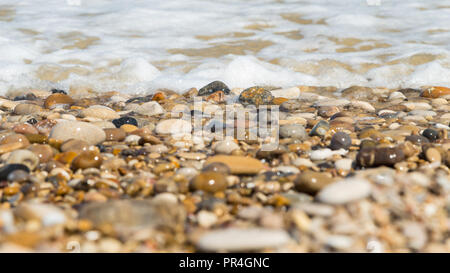 La pietra e la sabbia a riva in una giornata di sole Foto Stock