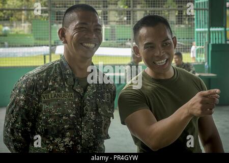Philippine Marine Sgt. Aldrin Villanueva (sinistra) e U.S. Navy Lt. Brian Bonzo (destra) ridere insieme durante KAMANDAG 2 a Ternate Centrale Scuola elementare a Ternate, Cavite, Filippine, Sett. 13, 2018. Esercitazioni bilaterali quali KAMANDAG 2 aumentare la capacità degli Stati Uniti e le Filippine per rispondere rapidamente e lavorare insieme durante il mondo reale di terrorismo o di crisi umanitarie al fine di compiere la missione, sostenere la popolazione locale e contribuire a mitigare la sofferenza umana. Villanueva, nativo di Naic, Filippine, è con il servizio di combattimento brigata di supporto e Bonzo, un nati Foto Stock