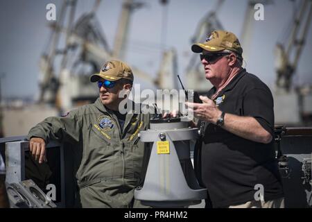 Salonicco, Grecia (sett. 14, 2018) Capt. George R. Aguilar, comandante della Blue Ridge-class di comando e di controllo nave USS Mount Whitney (LCC 20), a sinistra e a militari di comando Sealift mariner civile Kerry Grubb, chief's mate a bordo di Monte Whitney, vegliano sul ponte-wing come la nave parte Salonicco, Grecia, Sett. 14, 2018. Il Monte Whitney, distribuita a Gaeta, Italia, opera con un equipaggio combinato di U.S. I marinai della marina militare e Sealift comando servizio civile naviganti. Foto Stock