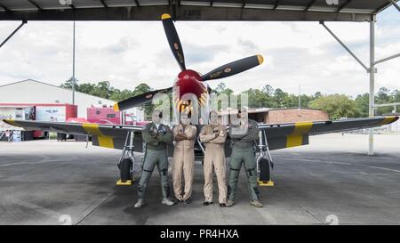 Il Mag. Paolo "Loco" Lopez, U.S. Air Force F-22 Raptor dimostrazione comandante del team e pilota, Keith Charlot, un fotografo di aviazione, Bradford Lang, il figlio di un Tuskegee Airman e pilota con Commemorative Air Force e il Mag. Ricca 'Sheriff" la pace, un F-16 Fighting Falcon istruttore pilota con il 100th Fighter Squadron, pongono di fronte a un P Mustang sett. 6, 2018 in campo Dannelly, Ala. Lopez, volare un F-22, Lang, volare un P-51 e Pace volare un F-16 eseguito un volo legacy su Tuskegee, Ala. in onore dell'eredità di Tuskegee. Foto Stock