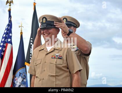 OAK HARBOR, nello Stato di Washington (Sett. 14, 2018) - Capo Elettricista Aviazione Daniel Jackson, attaccato al Patrol Squadron (VP) 47, ha il suo coperchio indossati da Chief Aircrewman (l'operatore) Christopher Aiu durante la Naval Air Station Whidbey Island (NASWI) chief petty Officer (CPO) cerimonia di pinning. La cerimonia segna la prima iterazione del marinaio 360 e il culmine di un periodo di sei settimane di lunga e intensa del ciclo di formazione che è stata costruita al largo di quasi due secoli e mezzo di patrimonio navale e 125 anni di tradizione di OPC. VP-47 vola il P-8A Poseidone, la Marina's premiere long-range anti-guerra sottomarina platform Foto Stock