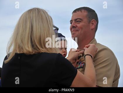 Porto, nello Stato di Washington (Sett. 14, 2018) - Capo Aircrewman (l'operatore) Douglas Blynn, attaccato al Patrol Squadron (VP) 47, ha la sua ancore sporche riposte su da sua moglie durante il Naval Air Station Whidbey Island (NASWI) chief petty Officer (CPO) cerimonia di pinning. La cerimonia segna la prima iterazione del marinaio 360 e il culmine di un periodo di sei settimane di lunga e intensa del ciclo di formazione che è stata costruita al largo di quasi due secoli e mezzo di patrimonio navale e 125 anni di tradizione di OPC. VP-47 vola il P-8A Poseidone, la Marina's premiere long-range anti-sommergibile warfare piattaforma. Il 'Golden spadaccini' ha Foto Stock