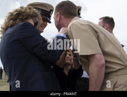 Porto, nello Stato di Washington (Sett. 14, 2018) - Capo di aviazione del macchinista Mate Joshua Ginieczki ha il suo imbrattata ancore riposte su dalla sua famiglia durante la Naval Air Station Whidbey Island (NASWI) Chief Petty Officer (CPO) Cerimonia di pinning. La cerimonia segna la prima iterazione del marinaio 360 e il culmine di un periodo di sei settimane di lunga e intensa del ciclo di formazione che è stata costruita al largo di quasi due secoli e mezzo di patrimonio navale e 125 anni di tradizione di OPC. VP-46 ha recentemente tornato da Rim del Pacifico esercizio ed è attualmente di stanza a NASWI. Il 'Cavalieri grigio' sono in preparazione per un prossimo dep Foto Stock