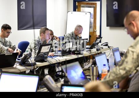 North Carolina aria guardie nazionali verificare le informazioni e la diffusione di un flusso continuo di comunicazione mentre assegnato al 145Airlift Wing Emergency Operation Center presso il North Carolina Air National Guard NCANG (Base), l'Aeroporto Internazionale Charlotte Douglas, Sett. 14, 2018. Avieri attraverso la base per preparare per interruzioni di energia elettrica e acqua danno che potrebbe verificarsi come risultato della tempesta tropicale Firenze. Il funzionamento di emergenza Centro, che in genere viene eseguito con più di 15 persone alla volta, è una 24 Ore di mozzo per l'assegnazione di risorse e persone in cui le aree interessate ne hanno più bisogno e comunicare fino Foto Stock