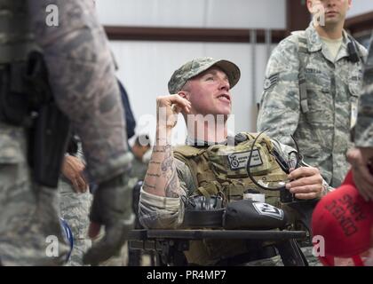 Master Sgt. Mathew Quinlan, 124a forze di sicurezza volo squadrone chief Boise, Idaho, e Air National Guard Defender sfida del membro del team, barzellette con un combat arms istruttore prima di iniziare la lotta contro le armi concorrenza durante la Air Force difensori Challenge 2018 a Camp Bullis, San Antonio, Texas, Sett. 11, 2018. La ripresa è una competenza essenziale per tutti pronti per il combattimento aviatori, specialmente per i FS. Foto Stock