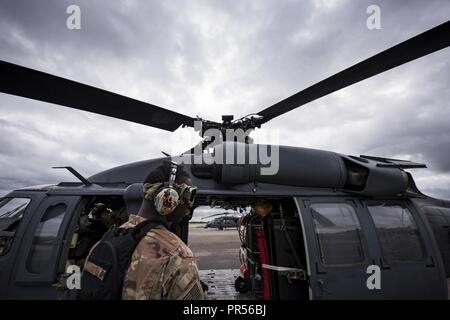 Un capo equipaggio assegnati al 334 Aria Gruppo Expeditionary prepara un HH-60G Pave Hawk per volo, Sett. 16, 2018 a base comune, Charleston S.C. La 334 AEG è un ricerca expeditionary e unità di salvataggio che è pre-posizionata per fornire sollievo nella scia della tempesta tropicale Firenze. Compreso di 23d Ala e 920th ala di salvataggio di personale e risorse, le 334 AEG è pronto per eseguire la superficie, ad ala fissa e rotante operazioni SAR quando necessario. Foto Stock