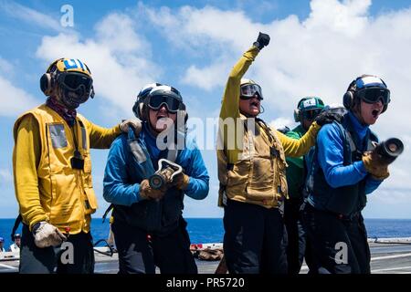 Mare delle Filippine (17 settembre 2018) marinai contro un aereo simulato il fuoco come parte di una massa casualty drill sul ponte di volo della Marina è distribuita portaerei USS Ronald Reagan (CVN 76) durante la Valiant scudo 2018. La biennale, SOLO NEGLI STATI UNITI, campo-esercizio di formazione si concentra sull'integrazione di formazione congiunta tra Stati Uniti Navy, Air Force e Marine Corps. Questo è il settimo esercizio nel Valiant scudo serie che ha avuto inizio nel 2006. Foto Stock