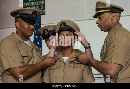 Mare delle Filippine (sett. 14, 2018) Marina Capo Consigliere Colietha Alvarez riceve la sua combinazione coperchio durante l'anno fiscale 2019 chief petty officer pinning cerimonia in un hangar bay a bordo della marina distribuita portaerei USS Ronald Reagan (CVN 76). Cinquanta-due marinai sono stati imperniati al rango di chief petty officer durante la cerimonia. Ronald Reagan, il portabandiera del Carrier Strike gruppo 5, fornisce un combattimento-pronto forza che protegge e difende la collettiva degli interessi marittimi dei suoi alleati e partner nella regione Indo-Pacifico. Foto Stock