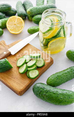 Focus su fette di cetriolo. Summer cocktail cetriolo limonata. Acqua rinfrescante con cetriolo, menta e limone su sfondo grigio. Bibita salutare e detox concetto. Spazio di copia Foto Stock