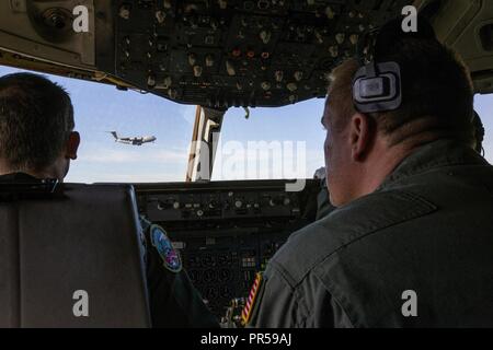 Stati Uniti Air Force Capt. Christopher D. Sampson, sinistra, una KC-10 Extender e pilota Tech. Sgt. Nicholas A. Stolley, una KC-10 Extender tecnico di volo, sia con la 78Air Refuelling Squadron, 514th aria mobilità ala, guardare come un C-17 Globemaster III si presenta per un atterraggio a base comuneGuire-Dix Mc-Lakehurst, N.J., Sett. 16, 2018. Il 514th è una Forza Aerea di riserva dell'unità di comando. Foto Stock