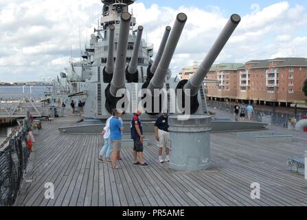 Royal ufficiali di marina tenente comandante Kathryn Jacques e tenente comandante Rupert Taylor, entrambi assegnati per la HMS Queen Elizabeth, ha visitato la USS Wisconsin (BB-64). Il tour è stato ospitato da Hampton Roads Museo Navale del coordinatore di volontariato, Darcy lavandino e volontario Dan Chamberlain. Foto Stock