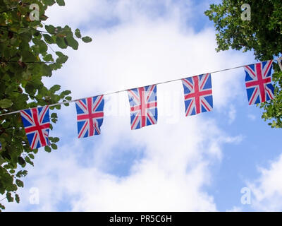 Rosso, bianco e blu festosa bunting bandiere contro lo sfondo del cielo. Union Jack, bandiere del Regno Unito. Brexit forse. Foto Stock