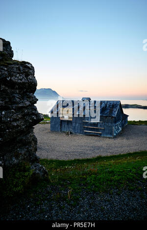 Un abbandonato edificio con travi di legno con graffiti nel paesaggio costiero dell est dell'Islanda. Foto Stock