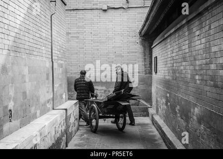 Lavoratori cinesi in strada di un hutong di Pechino Foto Stock