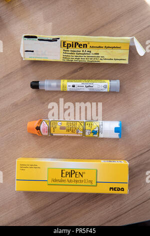 EpiPen autoejectors utilizzato per iniettare adrenalina in una vittima di anaphalaxis. Un vecchio nero iniettore con punta accanto a una versione più recente di orange ribaltato EpiPen cred Foto Stock