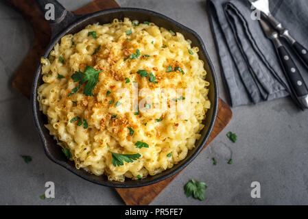 Mac e formaggio, stile americano maccheroni con salsa di formaggio e mollica di pane croccante topping su cemento Tabella, vista dall'alto Foto Stock