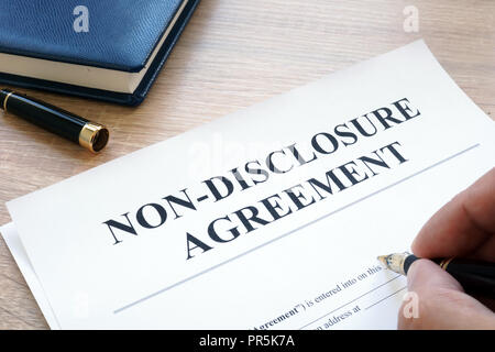 L uomo è il riempimento in accordo di non divulgazione NDA. Foto Stock