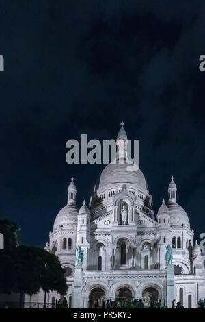 Parigi, Francia - 7 Agosto 2018: Basilica Sacre Coeur di Montmartre durante la notte ed è circondato da numerosi turisti. Foto Stock