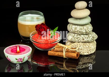 Piramide di ciottoli. Pietre sul tavolo. Il resto per il caffè. Concetto di benessere. La meditazione con la candela Foto Stock