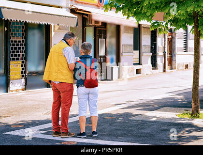 Coppia con mappa turistica in strada nel centro storico di Lubiana, Slovenia Foto Stock
