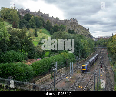 Edimburgo, Scozia - 27 settembre 2018: un treno di andare in stazione ferroviaria Waverley di Edimburgo. Il Castello di Edimburgo è in background. Foto Stock