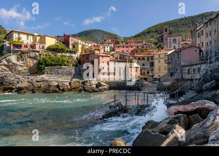 Bellissima vista del villaggio sul mare di Tellaro in una giornata di sole, La Spezia, Liguria, Italia, con le onde che si infrangono sulle rocce Foto Stock