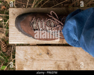 Close up di uomo di piede nella scarpa a piedi su un montante verticale Foto Stock