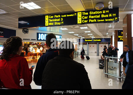 Persone in attesa per le persone presso la sala degli arrivi presso l'Aeroporto Internazionale di Manchester, Regno Unito Foto Stock