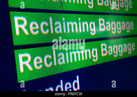 Recupero informazioni sul bagaglio segno nella sala degli arrivi presso l'Aeroporto Internazionale di Manchester, Regno Unito Foto Stock