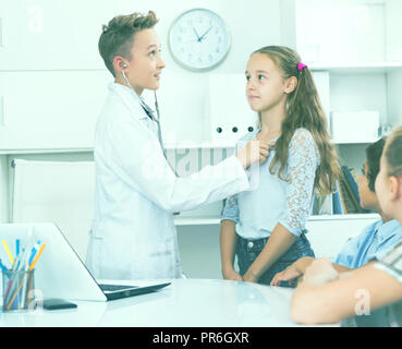 Giovane maschio medico in uniforme medica leader appuntamento con i bambini Foto Stock