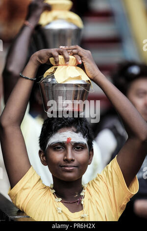 Ragazzo porta pot di latte sulla testa durante il festival di Thaipusam a Grotte Batu in Selangor, Malaysia Foto Stock