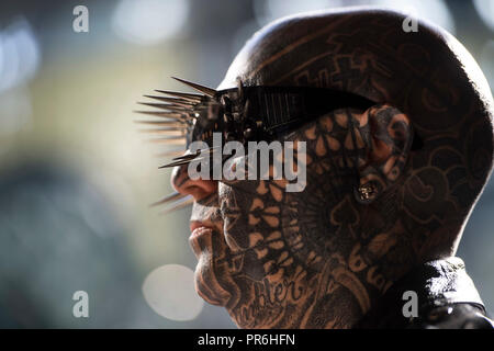 Un uomo si mette in mostra il suo tatuaggio durante la International Tattoo Convention al Dock del tabacco nella zona est di Londra. Foto Stock