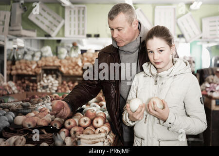 Allegro preteen bambina con il padre la scelta di mele mature mentre lo shopping in greengrocery Foto Stock